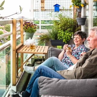 2 oudere mensen zitten op een balkon