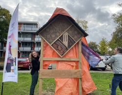 Een groot zeil wordt van het insectenhotel afgetrokken om deze te onthullen