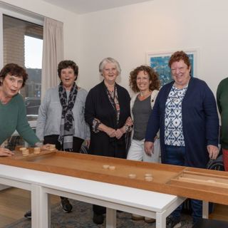 groep mensen rond een sjoelbak