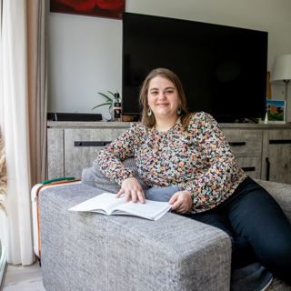 meisje zit in een stoel en lees een boek