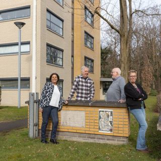 2 dames en 2 heren leunend tegen een muurtje