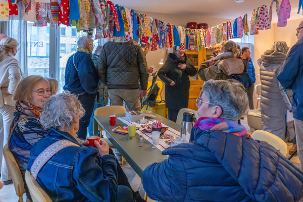 bezoekers staan en zitten in een huiskamer