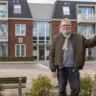 man leunt met 1 hand tegen boom